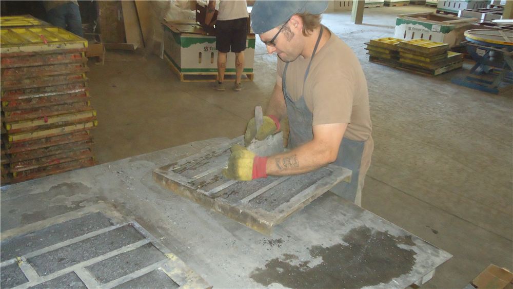 Worker finishing a mold on the plant floor